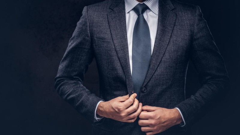 cropped-portrait-successful-businessman-buttoning-his-elegant-suit-isolated-dark-background