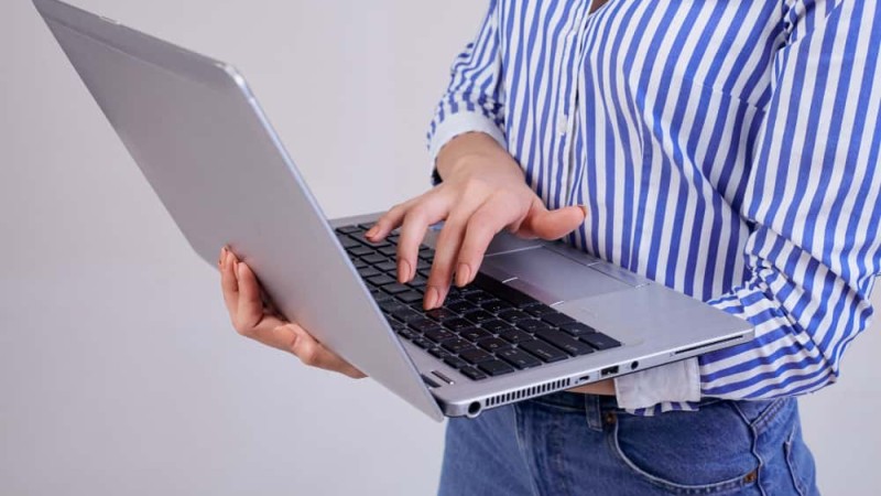 female-manager-striped-white-blue-shirt-with-laptop-standing-gray-employee-year-business-lady-worker